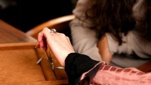 customer looking at diamond halo engagement ring on hand